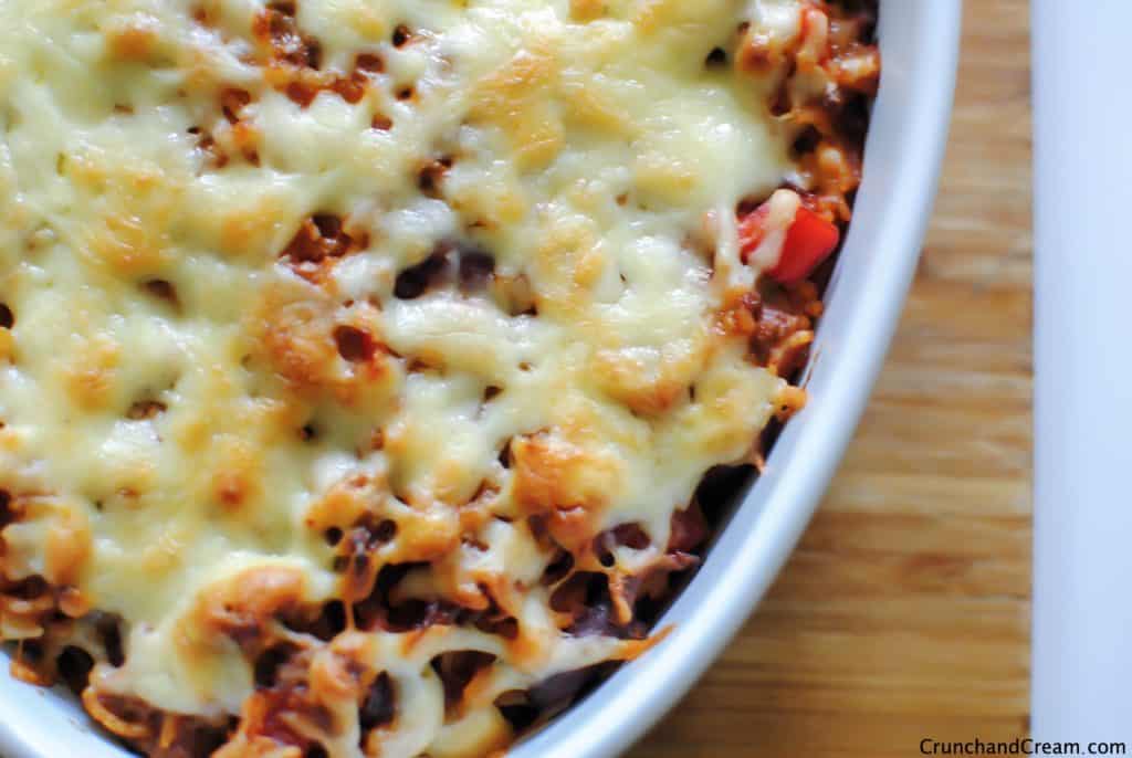 This cheesy Mexican rice bake is deliciously spicy. With rice, ground beef, chilli peppers and kidney beans baked in a spicy tomato sauce and topped with melty cheese, it really is a perfect comforting dinner!