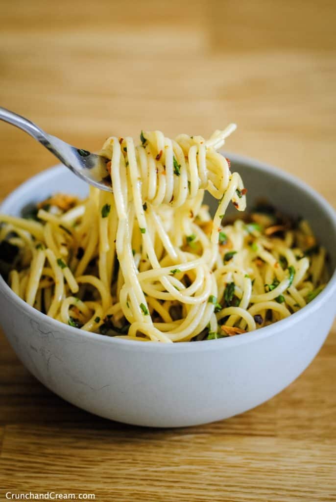 simple garlic basil pasta (spaghetti) wound around a fork