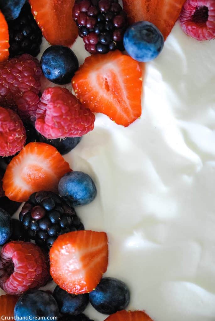 close up with one side of mixed fresh berries and the other as white cheesecake mixture