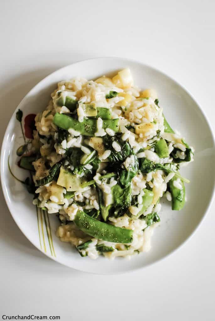 a plate of green vegetable risotto with spinach, sugar snap peas, leeks and herbs