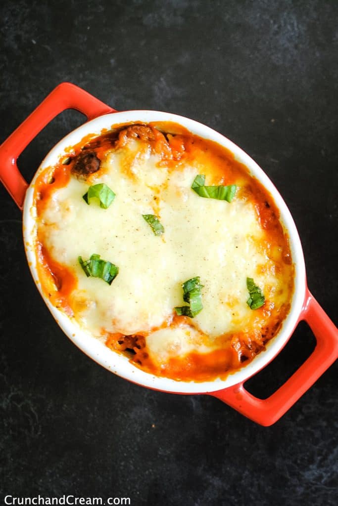 overhead of a casserole dish full of baked rice in a tomato sauce topped with melted cheese