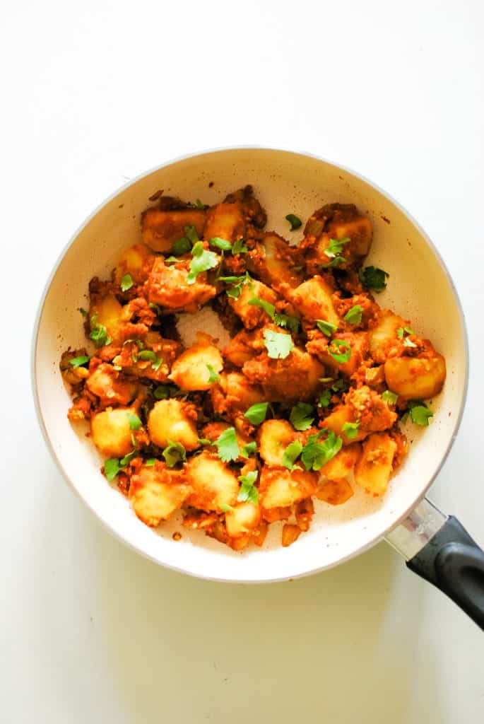 frying pan full of potatoes in a red sauce