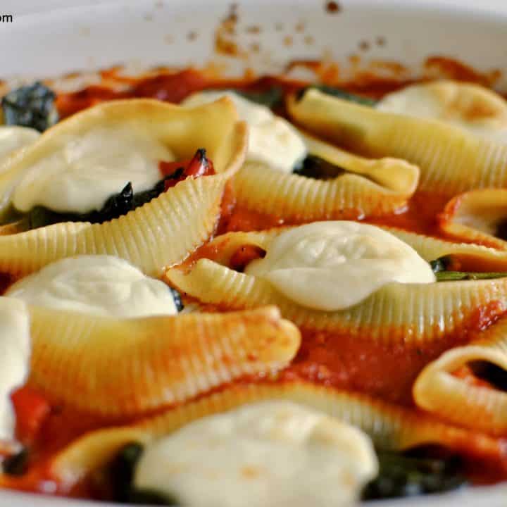front-on view of stuffed pasta shells with spinach, pesto, peppers and mozzarella