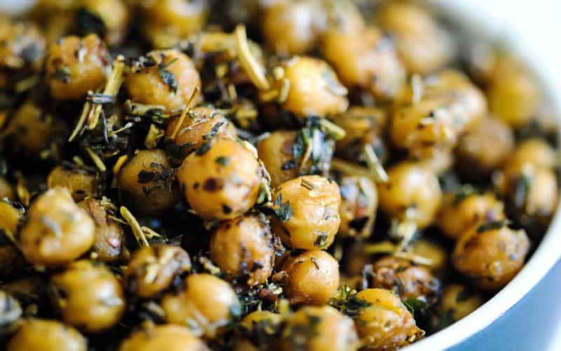 close-up side-on of golden, crispy roasted chickpeas covered in Italian herb seasoning